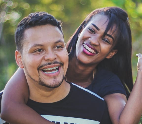 Good looking couple in the woods with woman hanging on mans back