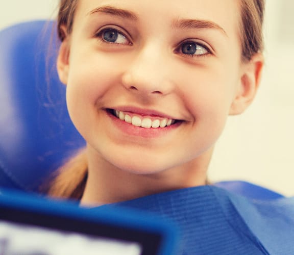 Woman sitting in a dental chair listening to what the dentist has to say